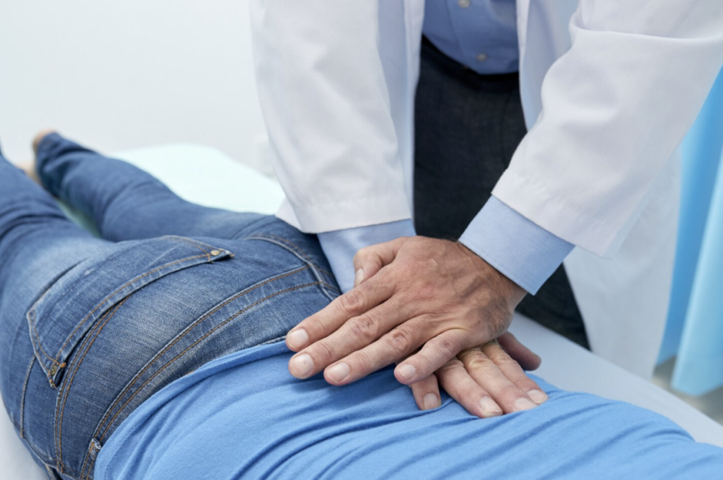 Chiropractor performing hands-on treatment on a patient's back during an appointment.
