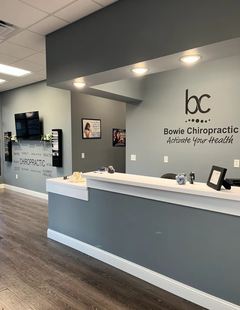 Bowie Chiropractic front desk welcoming a new patient for a first chiropractic visit.