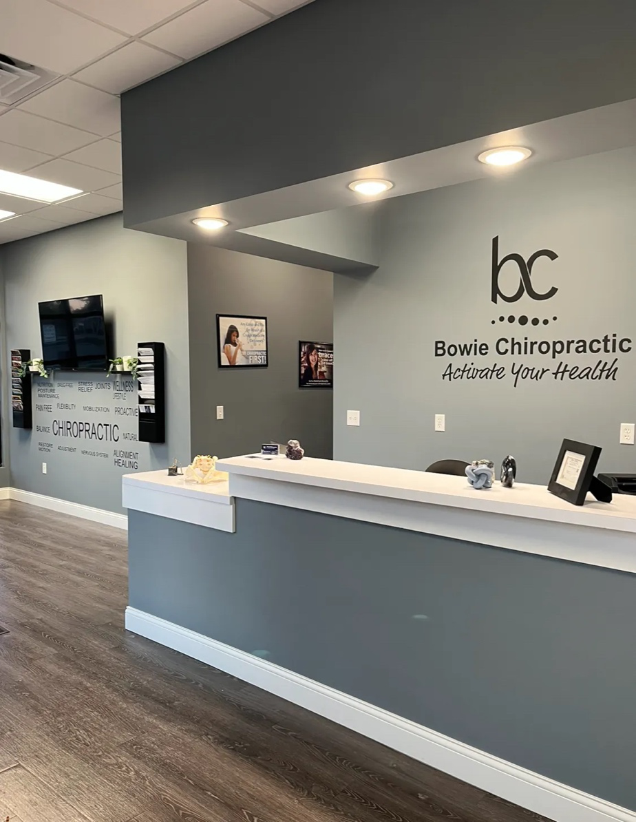 Bowie Chiropractic front desk welcoming a new patient for a first chiropractic visit.